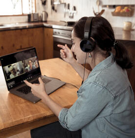 Mujer joven en una computadora portátil durante una reunión virtual